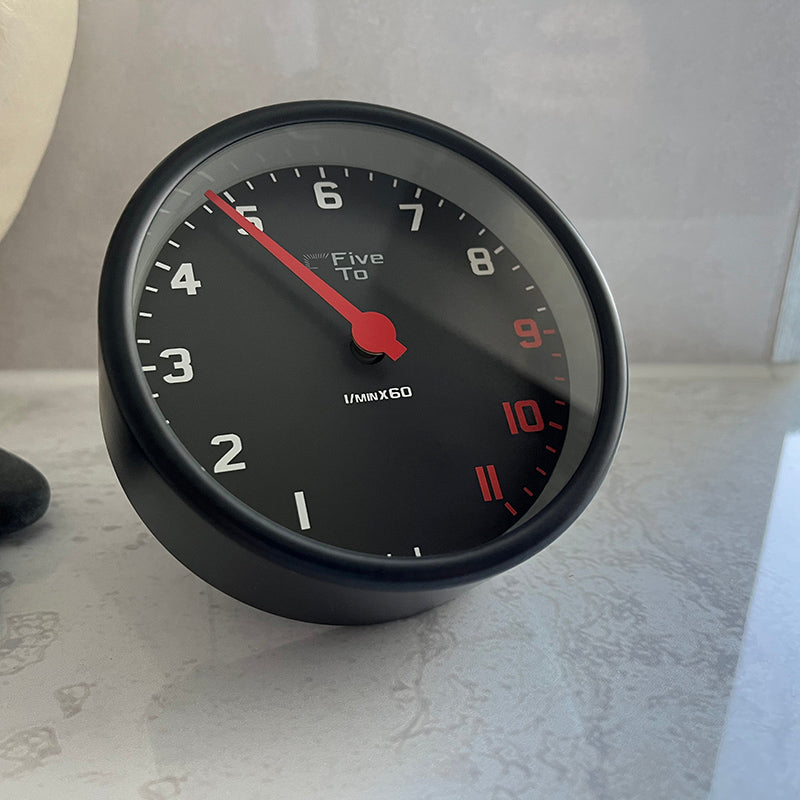 FiveTo Desktop Tacho Clock, front left view. Timekeeping redesigned in the style of a sports car rev counter. Exclusively available from www.fiveto.co.uk